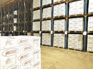 Almacén con palés de cajas de Mantecas Martínez en estanterías